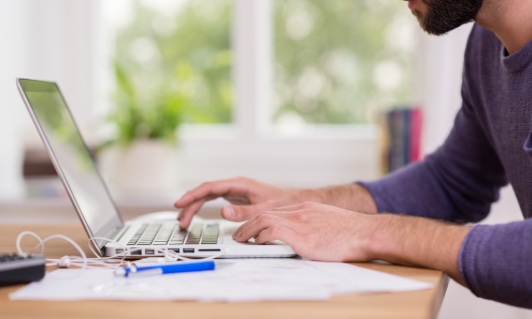 Man_working_laptop_purple_shirt